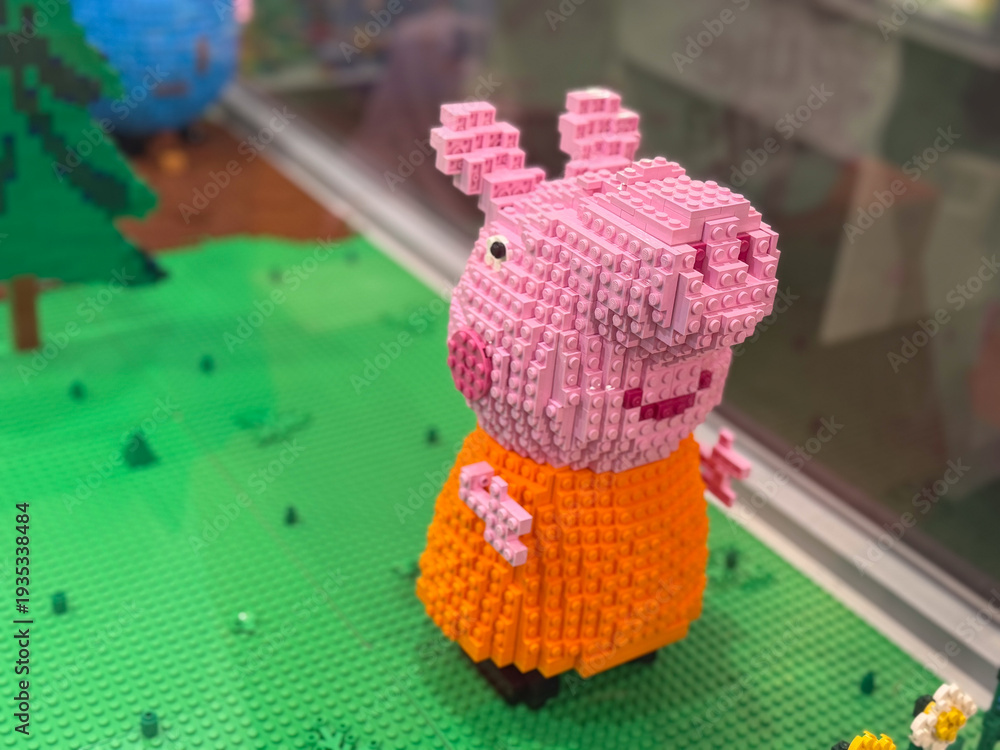 Fototapeta premium Mini pig brick sculpture on green baseplate