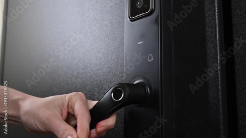A woman opens a modern smart door lock using a contactless key.