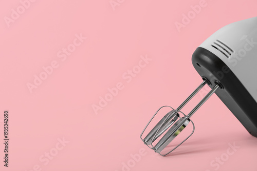 Electric mixer on pink back...
