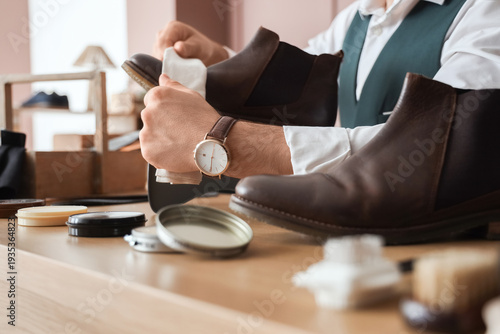 Male shoemaker polishing le...