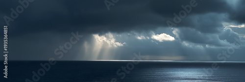 sunbeam slicing through heavy rain clouds over ocean horizon dramatic minimal stormscape
