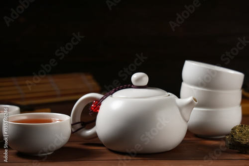Schilderij op canvas Teapot and cup with brewed Asian tea on dark wooden background