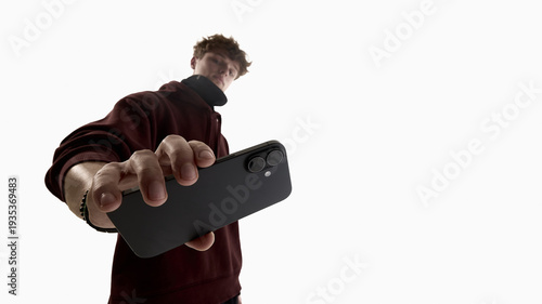 Schilderij op canvas Low angle young man holding smartphone toward camera isolated on white background
