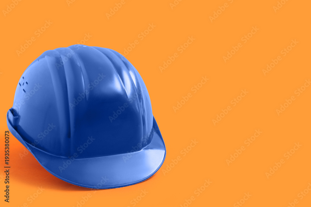 Fototapeta premium Blue hardhat on orange background