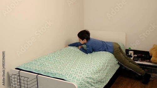 Young child makes the bed, pulling the blanket tight in a quiet bedroom, shot from the side with clean minimal walls. Daily chores support independence, responsibility, and calmer family mornings.