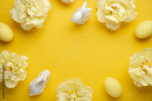 Happy Easter holiday background. Yellow Easter eggs and tulip flowers on yellow background top view. Greeting card, frame, banner.