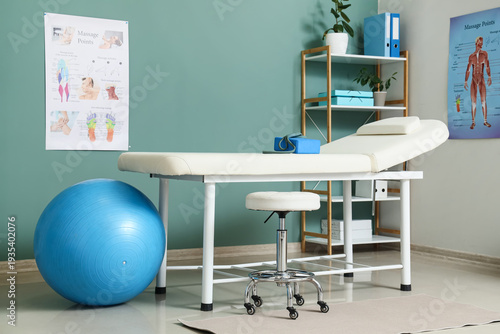 Interior of physiotherapist's office with couch, shelf unit and fitball