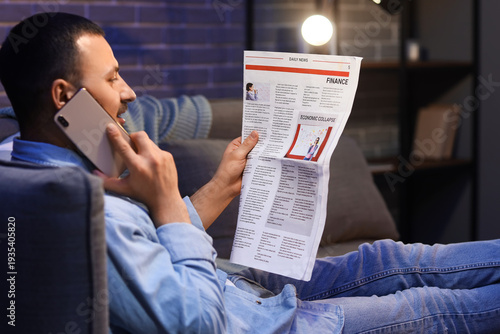 Young man with newspaper ta...