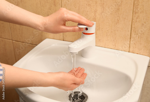 Woman washing hands in cera...