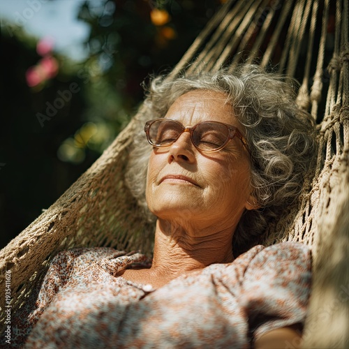 Senior woman lying in a hammock with closed eyes, quiet time in garden.
