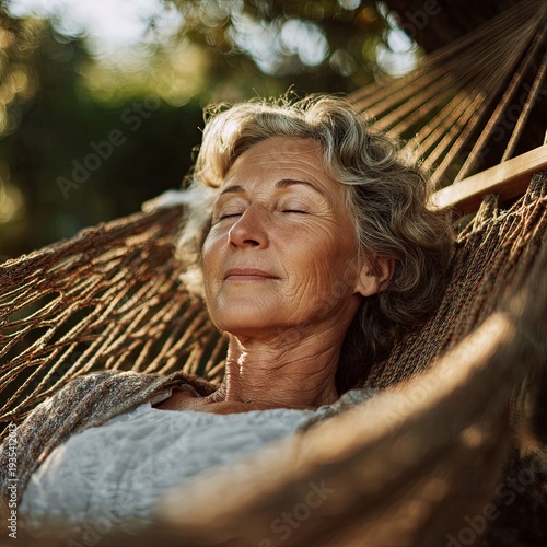 Senior woman lying in a hammock with closed eyes, quiet time in garden.
