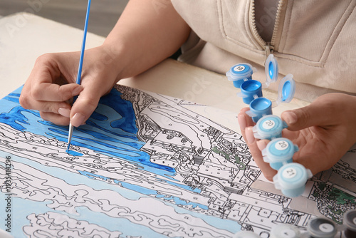 Woman paints on canvas for ...