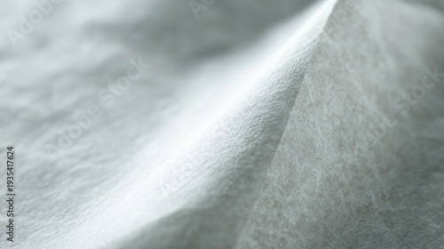 Soft white fabric folds gently. Light reflects off its smooth texture. Subtle creases add depth to the surface. Minimalist design suits modern aesthetics. Ideal for fashion, design