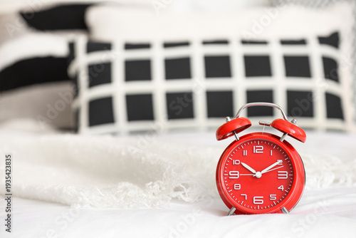 Red alarm clock on bed, clo...