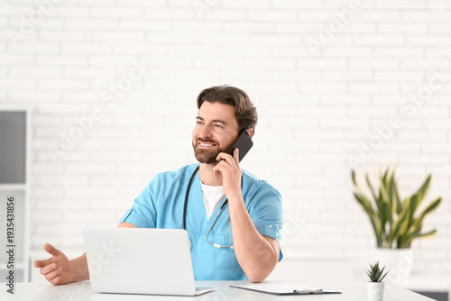 Handsome doctor talking by ...