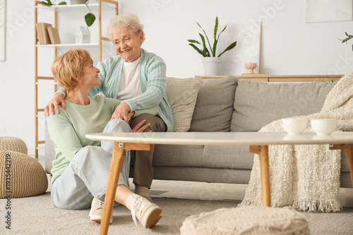 Senior woman hugging her daughter at home. Mother's Day celebration