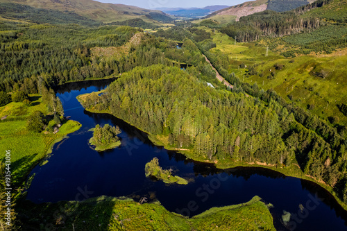 Aerial View of a Dark Blue Lake Surrounded by Green Forest