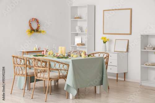 Beautiful table setting with decorative bunnies and Easter eggs in dining room