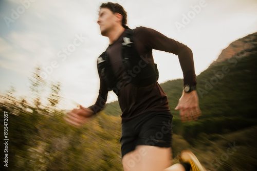 Foto Dynamic motion blur photograph of a trail runner sprinting along a mountain trail during outdoor endurance training