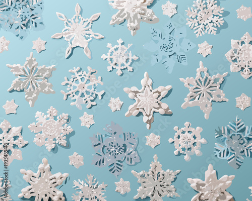 Paper snowflakes scattered on a light blue background creating a winter scene