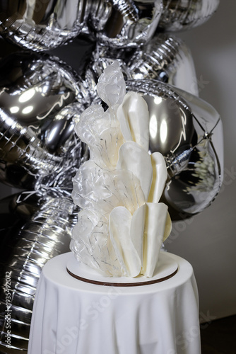 Elegant modern white cake with abstract translucent sails and silver foil balloons, perfect for luxury weddings, birthdays, and minimalist celebrations