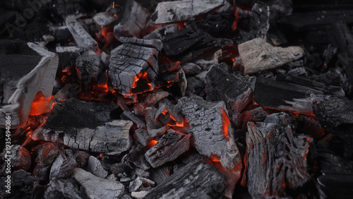 Billede på lærred Close up of smoldering charcoal with glowing embers and ash texture in low light, ideal for fire, heat, grilling, fuel, and dramatic background concepts