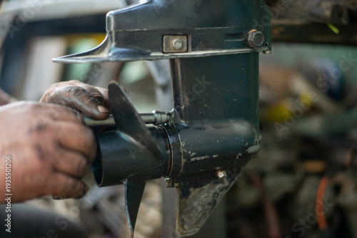 Canvastavla hands of a master auto mechanic repair a gasoline outboard marine engine