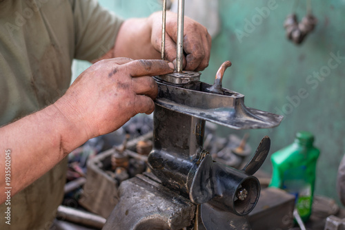 Foto The hands of a master auto mechanic repair transmission of outboard marine engine