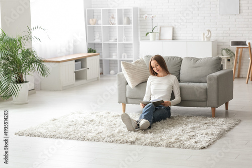 Young woman reading book on...