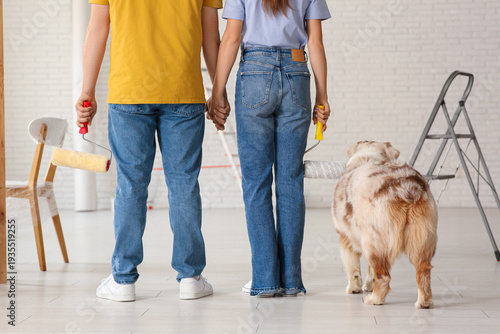 Canvastavla Young couple with cute dog and rollers planning painting walls in their new home