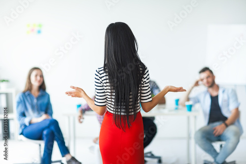 Rear view of woman business coach gesturing with hand