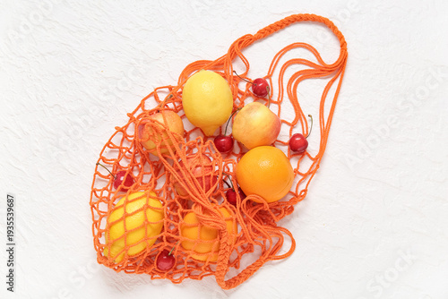 Mesh bag with fresh fruits ...