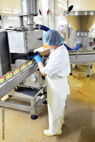 Production of sausages on a conveyor belt in a large meat processing plant - Industrial food processing - Workers in work clothes