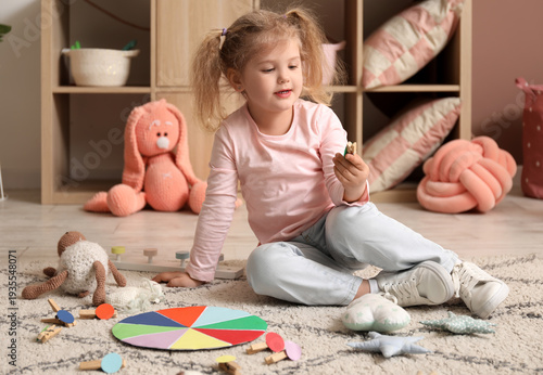 Cute little girl playing ma...