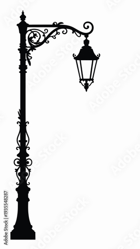 Vintage iron street lamp with glass lantern glowing at night in an old town street
