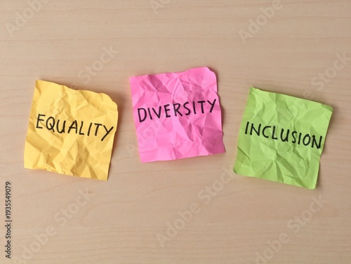 Equality, inclusion, and diversity words handwritten on colorful sticky notes on wooden desk background 