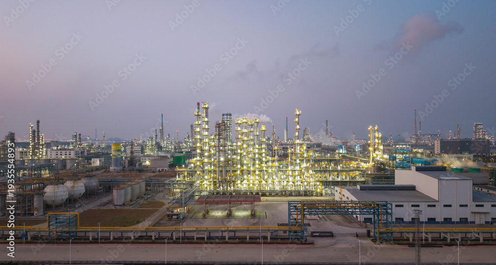 Fototapeta premium Refinery and chemical plant complex illuminated by night lights