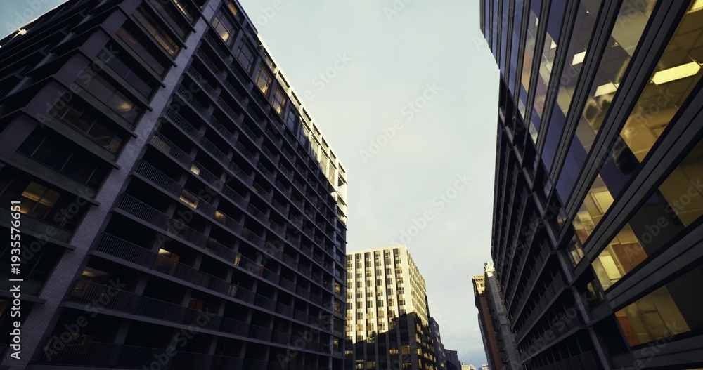Naklejka premium upward view of clustered highrises under dramatic sky, textured facades catching late light, vertical geometry and repetitive windows creating bold