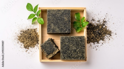 Artisanal soap displayed with greenery and grains on a white background
