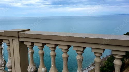 An ancient stone parapet overlooking the sea and clouds
