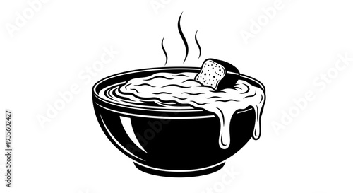 A steaming hot bowl of creamy soup with a crouton served in a black bowl from a high angle view