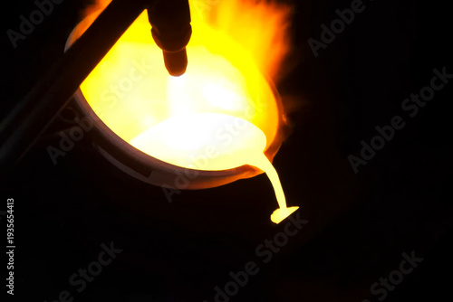 Gold in a melting pot molten by gas burner