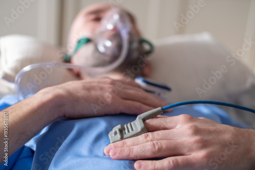 male patient in bed with oxygen mask, Human-centered health support, respiratory support, clinical ventilation interface obstructive sleep apnea treatment, medical breathing equipment in hospital