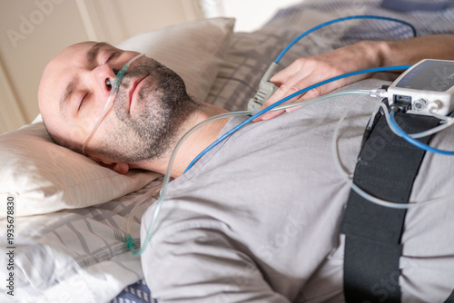 Obraz na plátně male Patient undergoing clinical sleep study diagnostic sensors, man sleeping wi