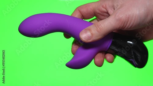 Pink dildo on a green background.
Sex toy