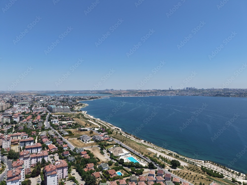 Fototapeta premium Aerial Panoramic View of Coastal Residential Neighborhood and Blue Sea Horizon