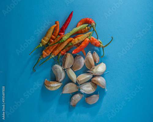 Fresh Chili Peppers and Garlic Cloves on Blue Background