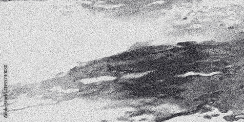 Abstract grayscale image with a dark, textured, cloud-like formation against a speckled background, evoking a sense of atmosphere or organic flow