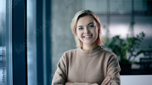 A woman is wearing a brown sweater and smiling