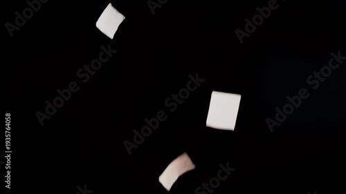 Floating Paper Pieces Against Black Background - Abstract Concept.
